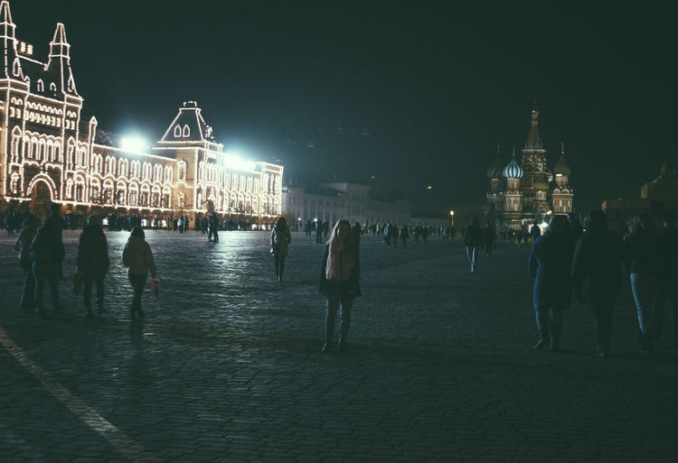 People on illuminated red square at night