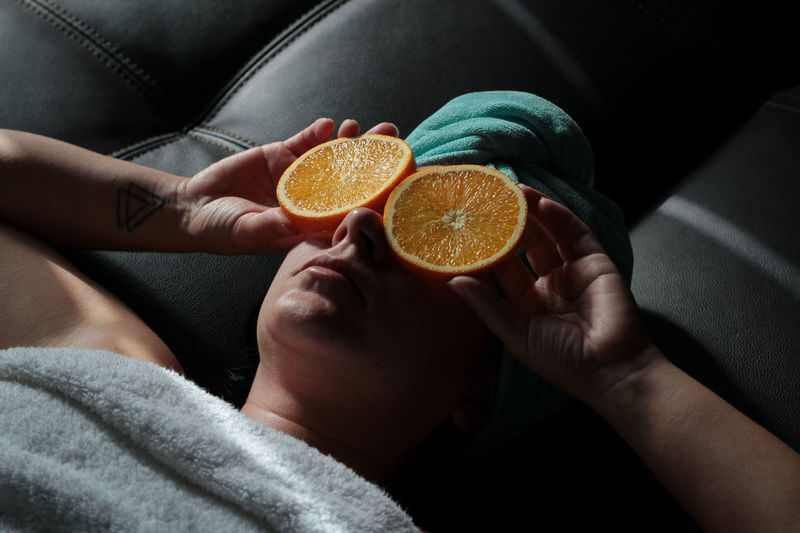 Midsection of woman holding orange slice 