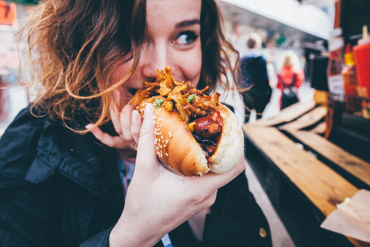 Eating Food Girl Holding Hot Dog Junk Food Ready-to-eat Woman Up Close Street Photography Street Food Worldwide