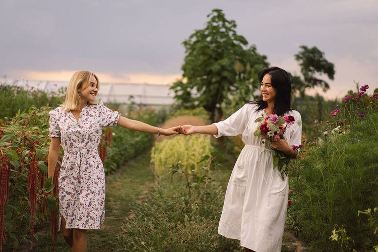 A young mother with a teenage daughter spends time in the garden. family holiday and togetherness.