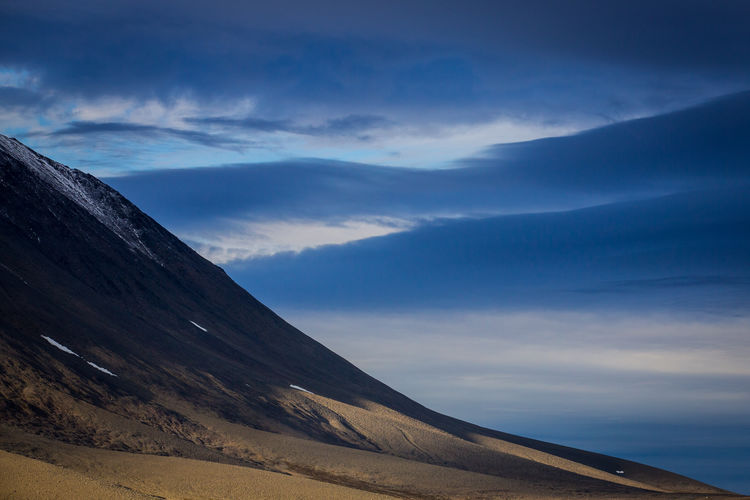 Scenic view of mountains against blue sky