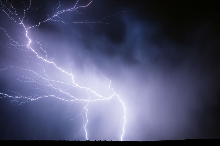 Lightning illuminates a thunderstorm in the night sky near stinnett, texas