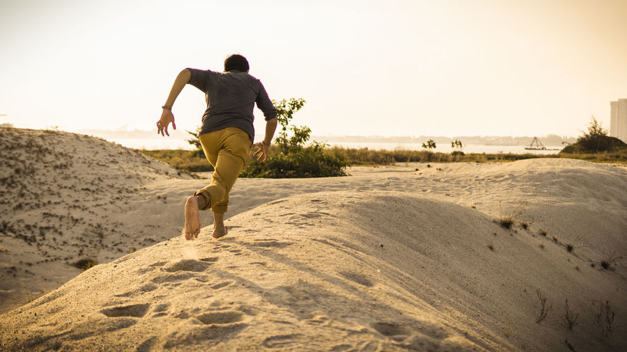 Rear view of man running on beach