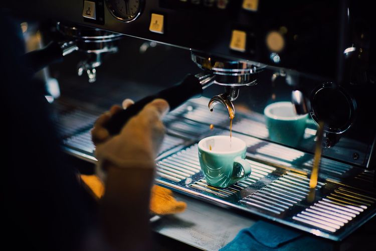 Midsection of barista working at cafe