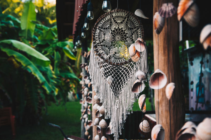 Handmade dream catcher with ornaments in natural green background in mexico