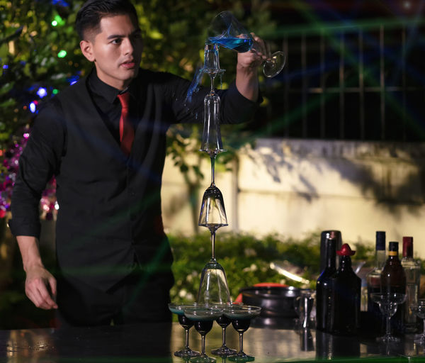 The bartender with a cocktail is preparing acocktail at the bar. barman making cocktail at nightclub