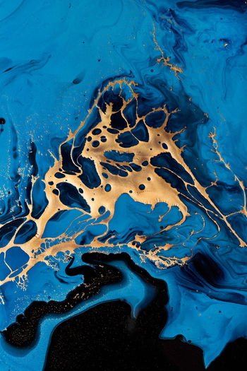 Dark blue waves in abstract ocean and golden inclusion. liquid acrylic artwork with flow and splash