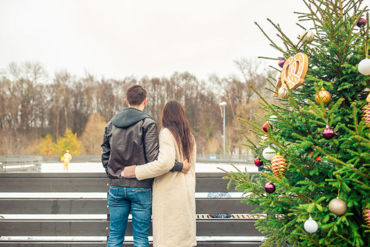 Rear view of couple standing in park during winter