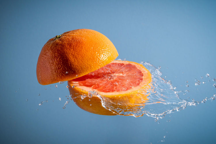 Close-up of orange fruit against blue background