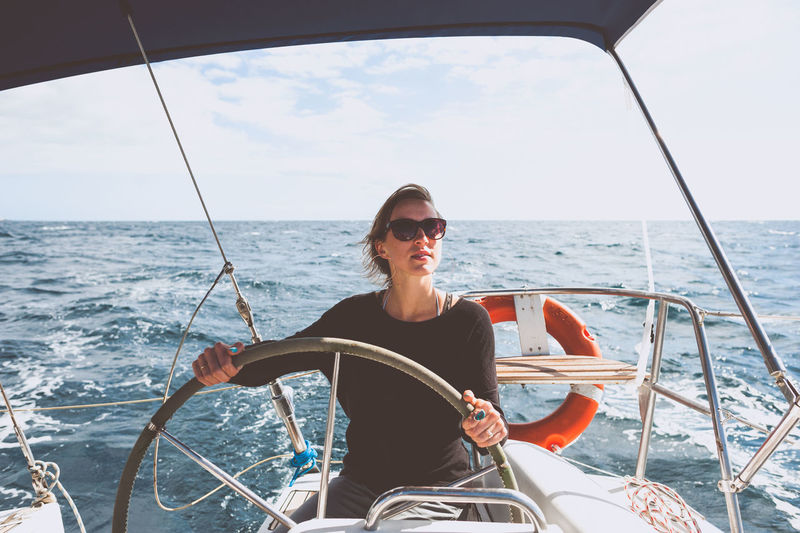 Young woman steering boat on sea