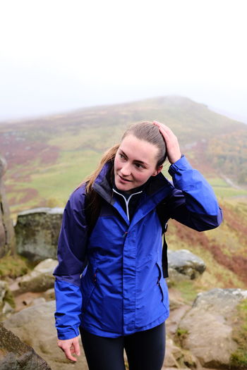 Portrait of young woman standing against mountain