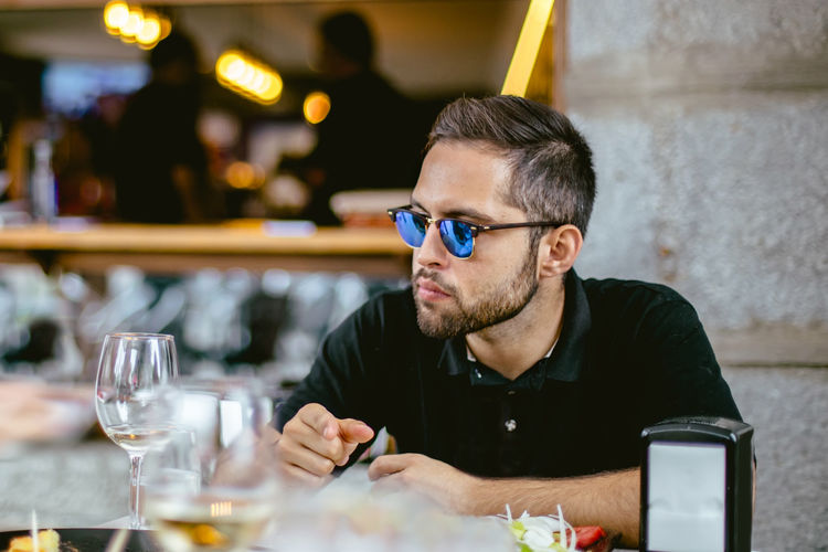 Man wearing sunglasses sitting at restaurant