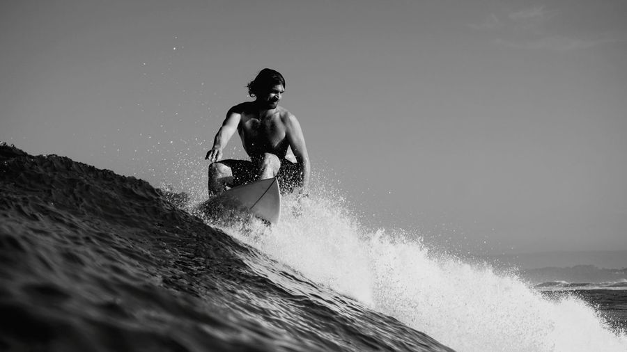 Man surfing on sea against sky