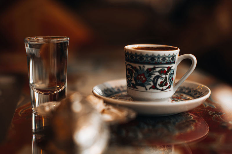 A cup of traditional black strong turkish coffee, sweets delight and a small glass of water. 