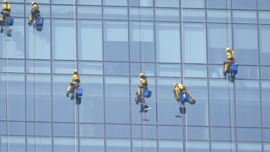 Low angle view of window washers cleaning office building