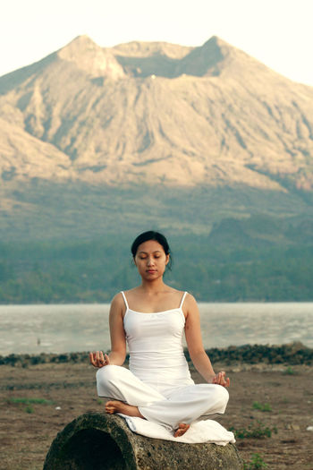 Woman doing yoga against mountains