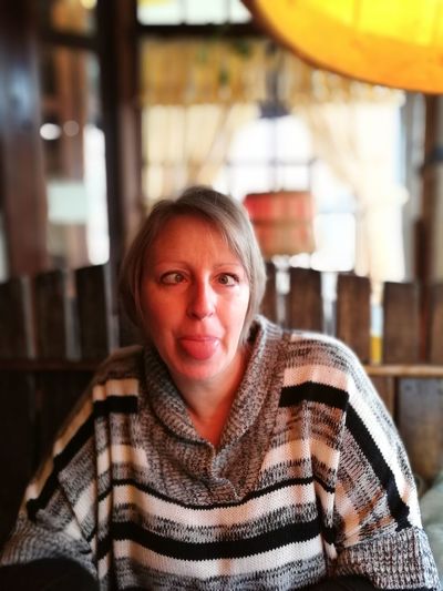 Funny woman making face in cafe