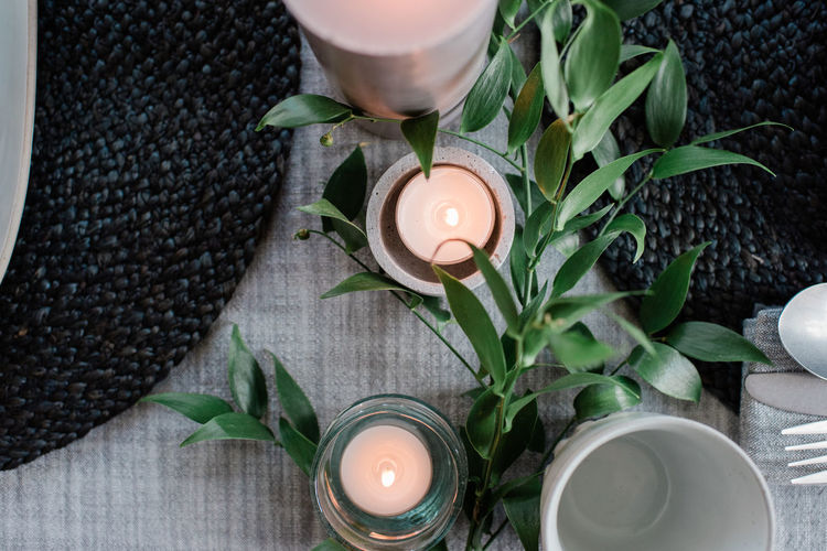Sky view of a candle on a romantic dinner table with plants