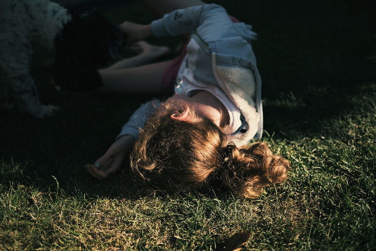 High angle view of girl lying on field
