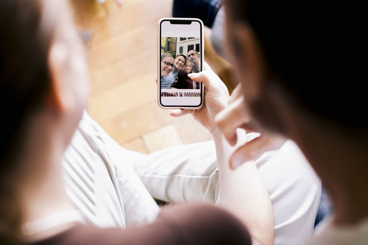 Siblings looking at family photo on smart phone