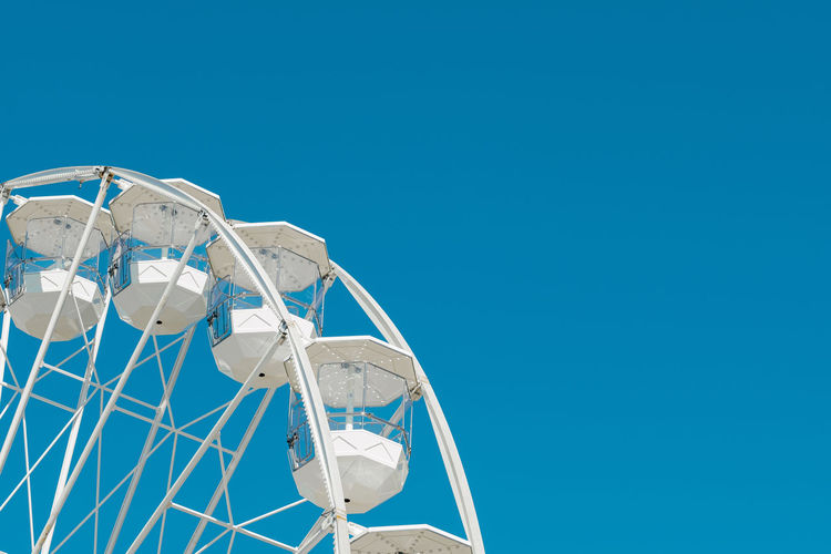 Part of ferris wheel in front of blue sky