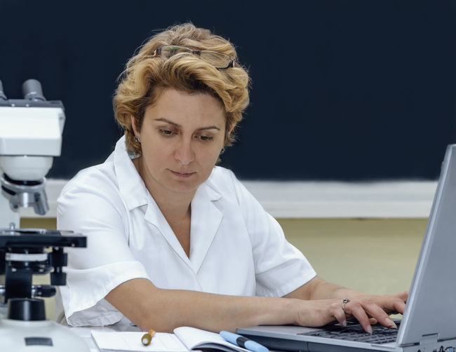 Scientist using laptop at laboratory