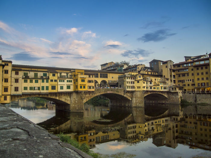 Low angle view of ponte vecchio on arno river against sky