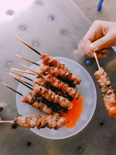 Cropped hand of person holding appetizer on table