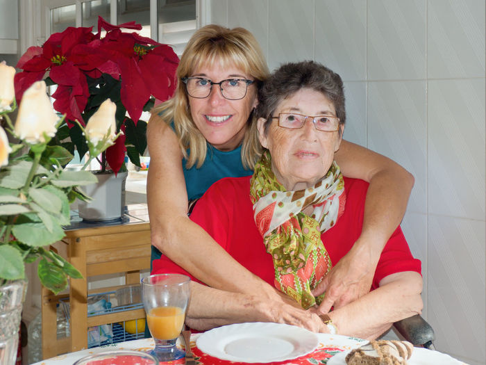 Portrait of smiling woman with mother at home