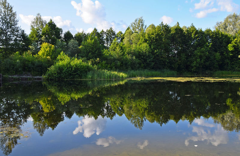 Scenic view of calm lake against cloudy sky