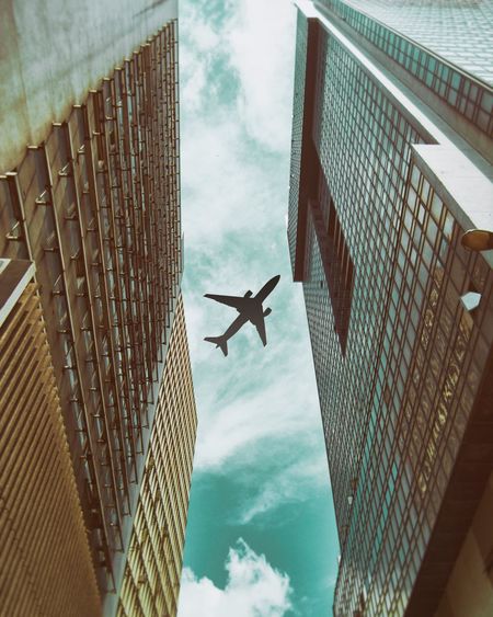 Low angle view of airplane flying over building