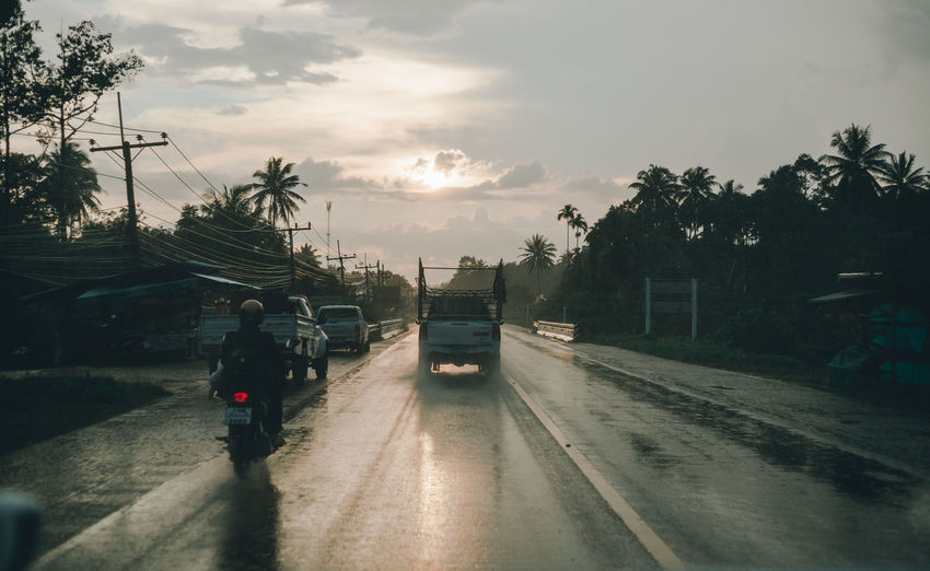 Cars on road against sky during rainy season