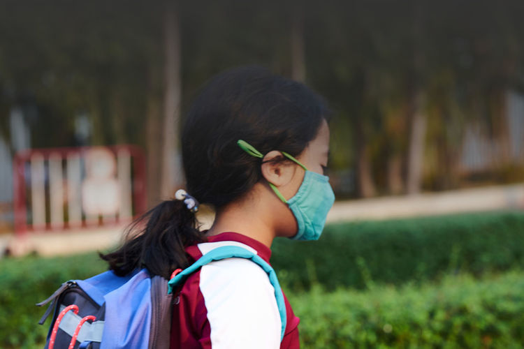 Kid with n95 mask protection from pm 2.5 dust crisis at school in pollution concept