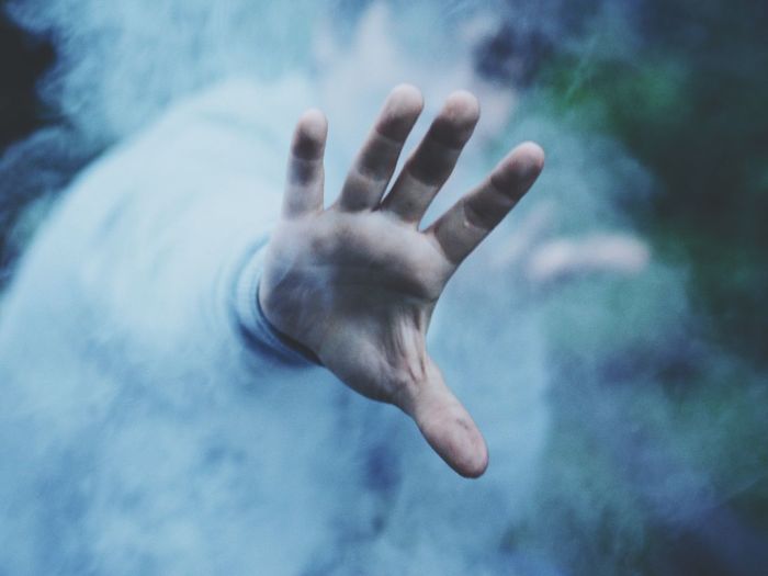 Close-up of male hand against smoke
