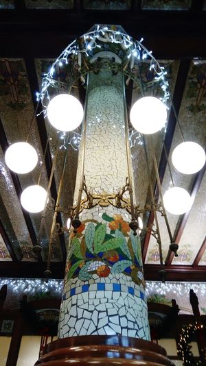 Low angle view of illuminated light bulb hanging at night