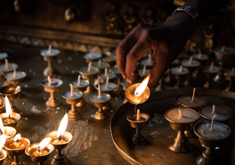 Cropped image of person pouring oil in diya