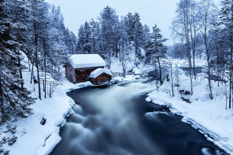 Blurred motion of river in snow covered forest