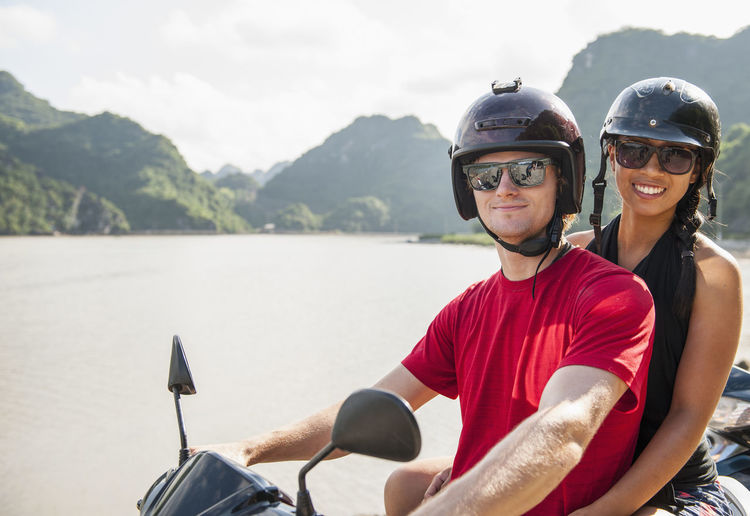 Young couple exploring cat ba island on a motor scooter
