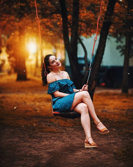 Woman sitting on swing at playground
