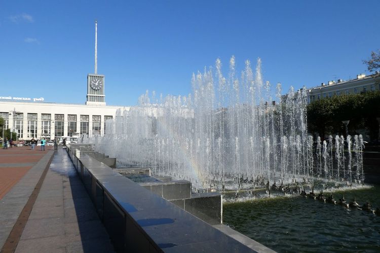 Fountain in city against clear sky