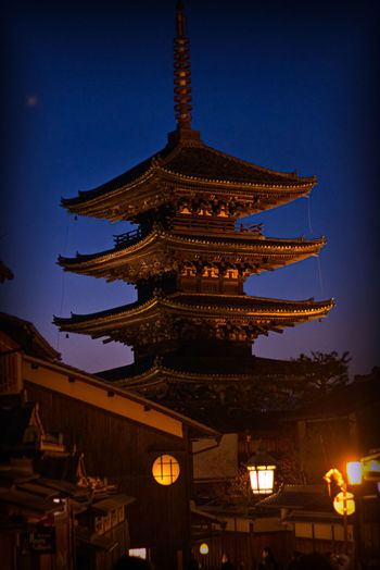 Low angle view of illuminated building against sky at dusk