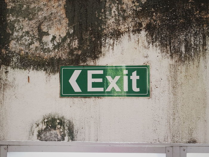 Close-up of exit sign on wall