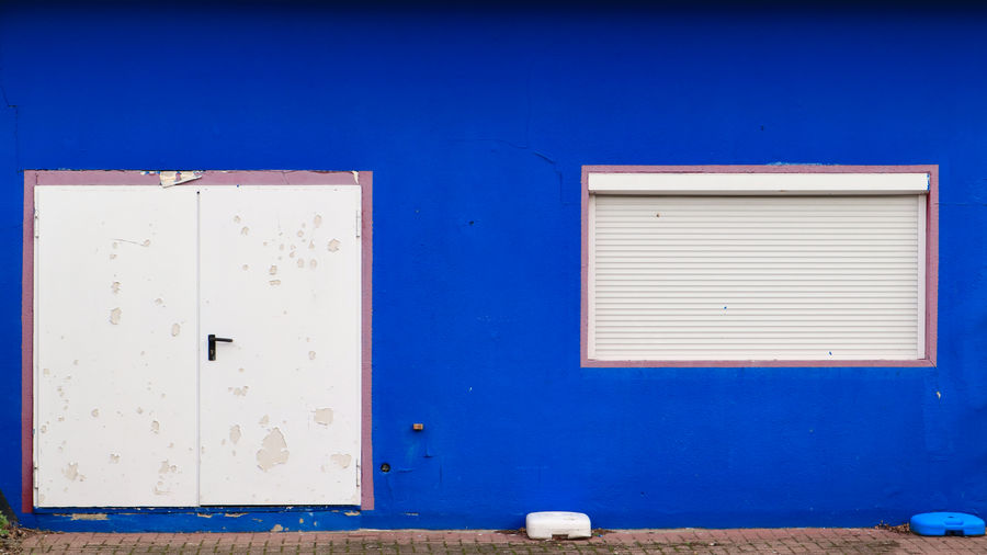 Close-up of blue door on white wall