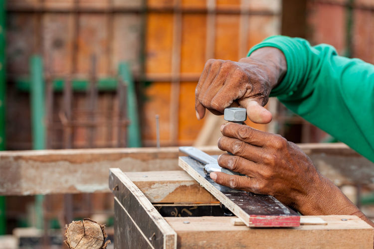 Cropped hand of carpenter working on wood