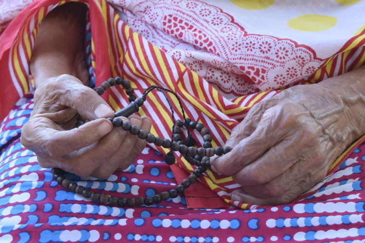 Close-up of senior woman holding prayer beads