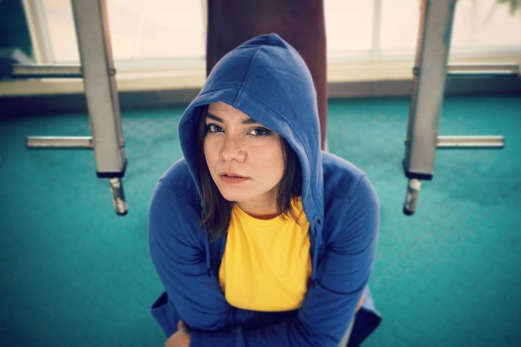 Portrait of woman in hood sitting at gym
