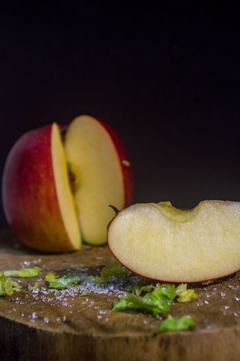Close-up of apple on table against black background