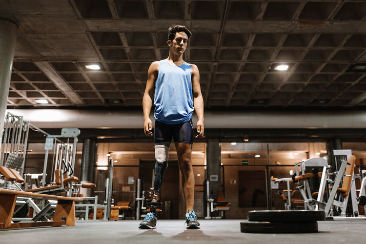 Man with artificial leg standing in gym