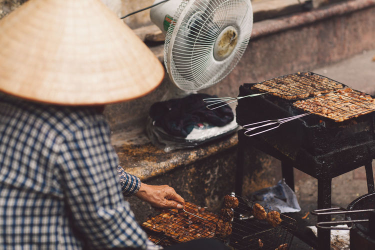 High angle view of man preparing food on barbecue grill