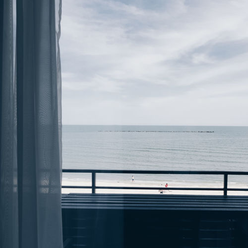 View of sea against sky seen through window